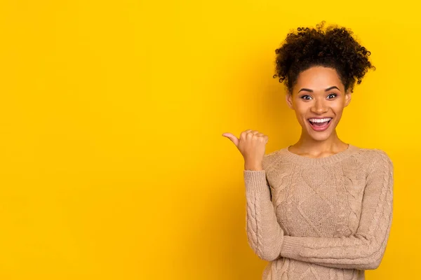 Photo of excited pretty lady dressed beige pullover pointing thumb empty space isolated yellow color background — Stock Photo, Image