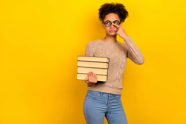 Fotografie vážné mladé brunetky dáma držet knihy vypadat promo nosit brýle svetr izolované na žlutém pozadí — Stock fotografie