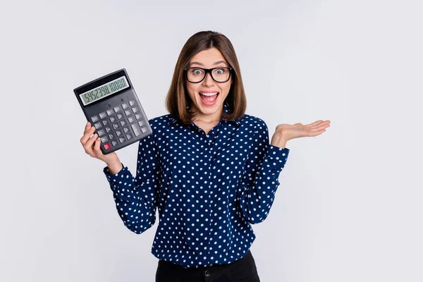Portret atrakcyjnej wesoły zdumiony dziewczyna gospodarstwa kalkulator oszczędności gotówki bawiąc się izolowane nad szarym pastelowym tle kolorów — Zdjęcie stockowe