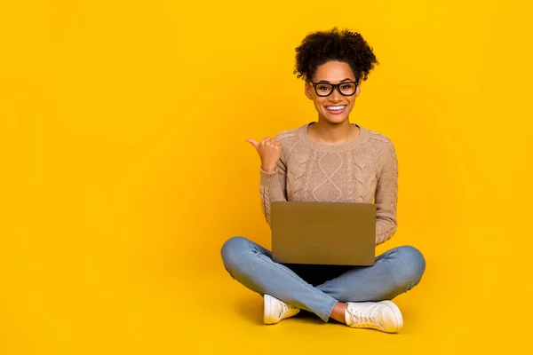 Full body foto van jong meisje duim lege ruimte direct selecteren aanraden promo laptop geïsoleerd over gele kleur achtergrond — Stockfoto