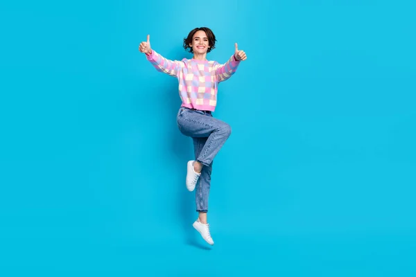 Full body photo of cool young brunette lady jump thumb up wear pullover jeans shoes isolated on blue background — 스톡 사진