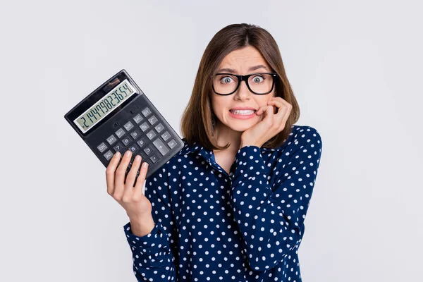 Portret atrakcyjnej przerażony nerwowy dziewczyna gospodarstwa kalkulator zła równowaga obgryzanie paznokci izolowane nad szary pastelowy kolor tło — Zdjęcie stockowe