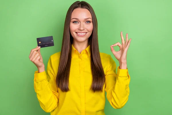 Foto av ung dam visa fingrar okey symbol rekommendera bankkort besparingar promo feedback isolerad över grön färg bakgrund — Stockfoto