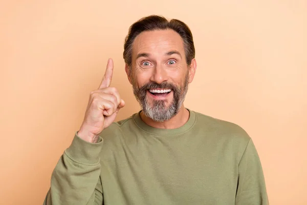 Ritratto di attraente allegro uomo stupito indicando indice fino buona soluzione isolata su sfondo di colore beige pastello — Foto Stock