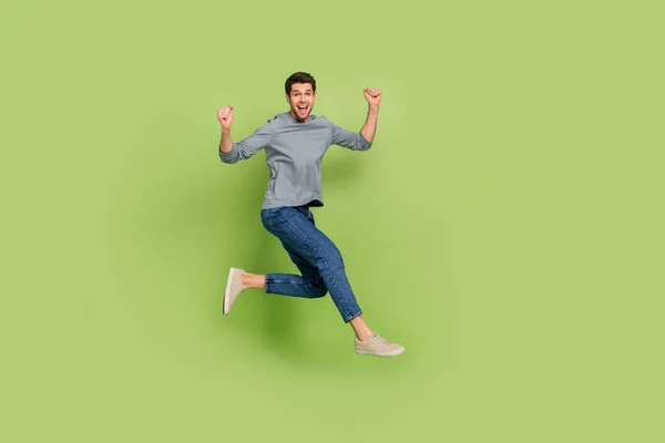 Full body profile side photo of cheerful man raise fists in success triumph isolated on green color background — Stockfoto