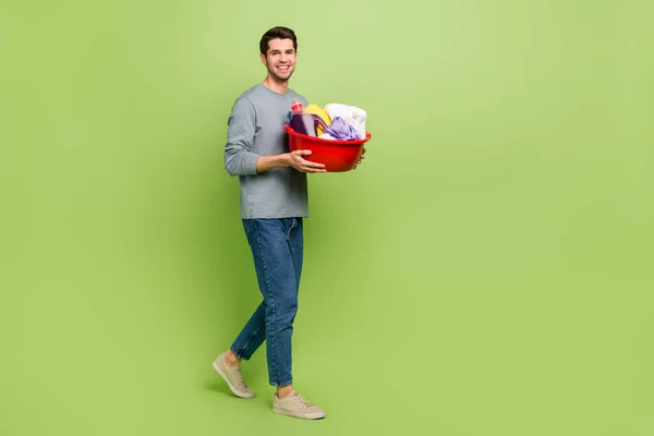 Full size profile side photo of cheerful handsome male prepare to do household chores isolated on green color background — Fotografia de Stock