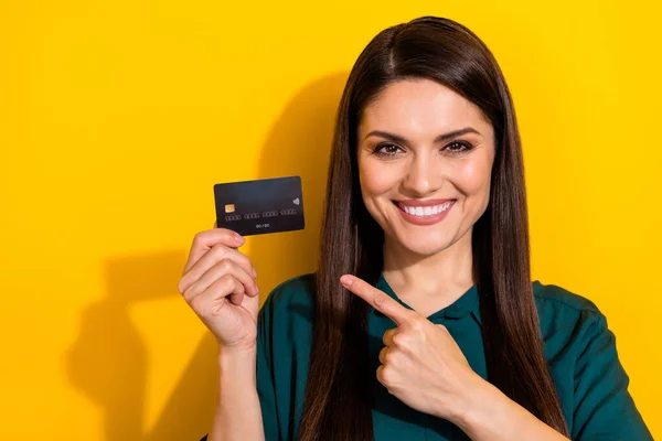 Photo of shiny pretty lady dressed green shirt pointing bank card isolated yellow color background — Stock Photo, Image