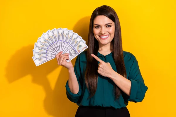 Foto de senhora doce bonito vestido camisa verde apontando dedo ventilador de dinheiro isolado cor amarela fundo — Fotografia de Stock