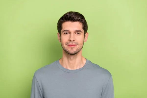 Photo of nice young brunet guy wear grey shirt isolated on green color background — Zdjęcie stockowe