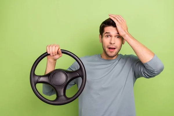Photo of impressed millennial brunet guy drive car hand face wear grey pullover isolated on green color background — Foto de Stock