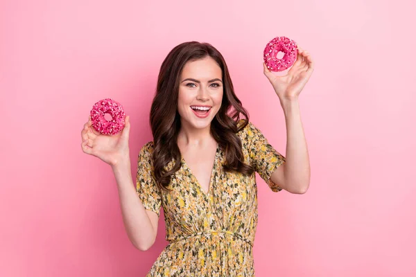 Portrait of cheerful pretty person hold two donuts beaming smile isolated on pink color background —  Fotos de Stock