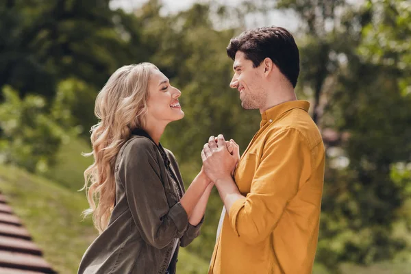 Profile side view portrait of beautiful handsome tender couple holding hands pastime honey moon outdoors — Stockfoto