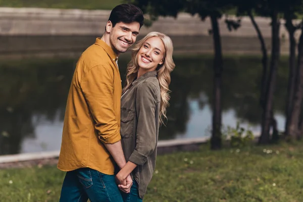 Profile side view portrait of cute cheerful couple life partners spending time cuddling enjoying on fresh air wood outdoors — Zdjęcie stockowe