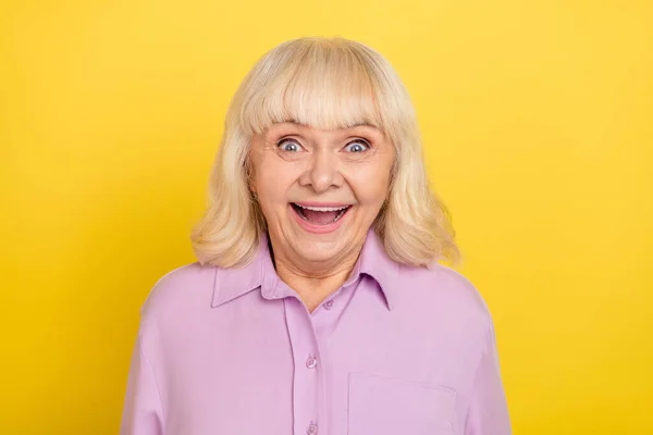 Portrait of attractive cheerful amazed grey-haired granny good news reaction isolated over bright yellow color background — Stockfoto