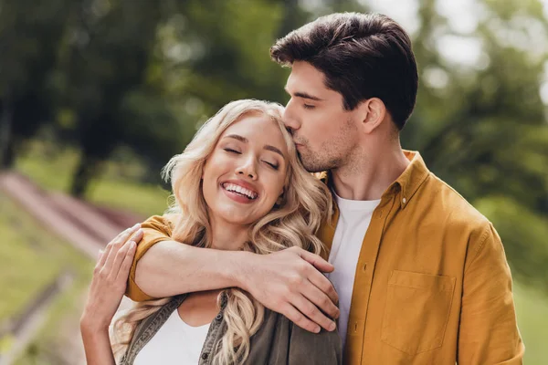 Portrait of beautiful handsome adorable couple kissing cuddling enjoying idyllic pastime honey moon outdoors — Zdjęcie stockowe