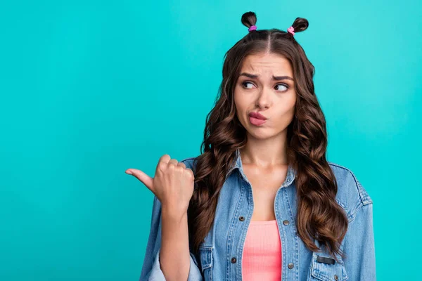 Photo of young lady unsure look indicate finger empty space proposition advert isolated over turquoise color background — 스톡 사진