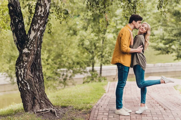 Full length body size profile side view of attractive cheerful dreamy couple hugging kissing romance time outdoors — Stok fotoğraf