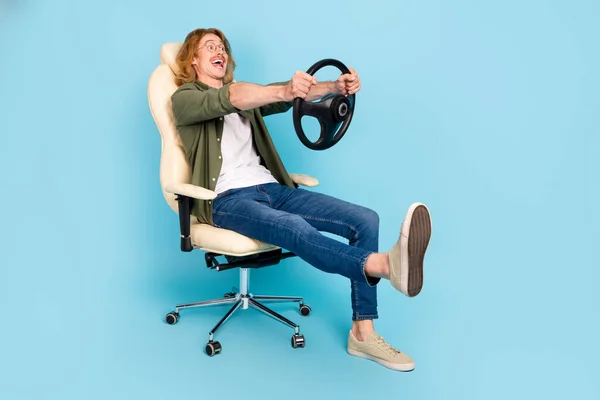 Full length body size view of attractive cheerful guy sitting holding steering wheel having fun isolated over pastel blue color background — Stock Fotó