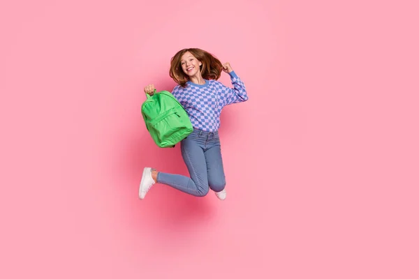 금발의 10 대 소녀가 점프하는 사진 전체가 핑크 색 배경에 고립된 가방 스웨터 운동화를 신고 있다 — 스톡 사진