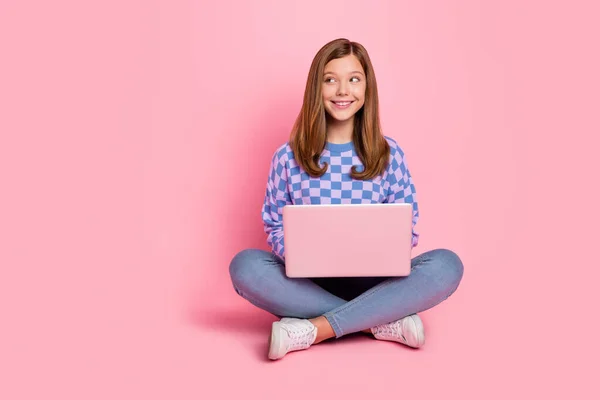 Full length photo of young girl sit floor use laptop dream idea look empty space isolated over pink color background — Zdjęcie stockowe