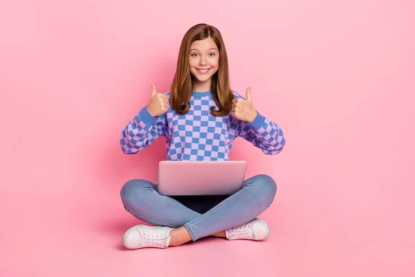 Full length photo of brown hairdo little girl hold laptop thumb up wear sweater jeans sneakers isolated on pink background — Stock fotografie
