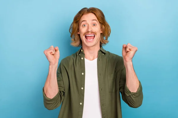 Portrait of attractive funky successful cheerful overjoyed guy rejoicing having fun isolated over pastel blue color background — Stockfoto