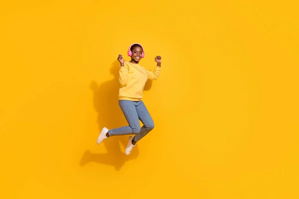 Full length body size view of attractive cheerful girl fan jumping listening hit pop isolated over bright yellow color background — Fotografia de Stock