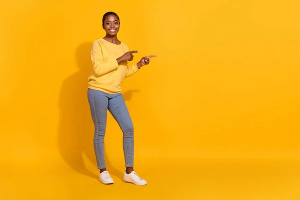 Full length body size view of attractive cheerful girl demonstrating copy space advert ad offer isolated on bright yellow color background — Stockfoto