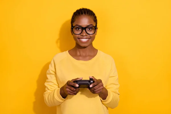 Portret van aantrekkelijke vrolijke meisje spelen video game besteden vrije tijd geïsoleerd over helder gele kleur achtergrond — Stockfoto