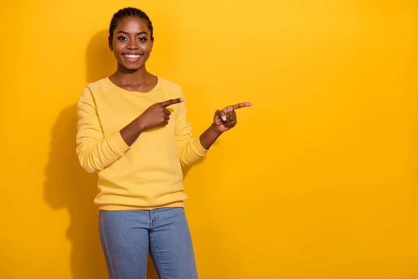 Portrait of attractive cheerful girl demonstrating copy blank space solution isolated over vivid yellow color background — Stock Fotó