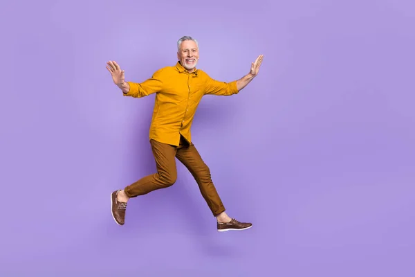 Full size photo of excited mature man have fun jump up energetic isolated over purple color background — Zdjęcie stockowe