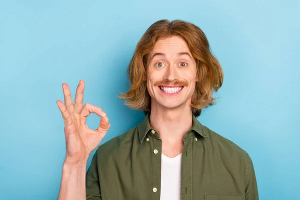 Portrait of attractive cheerful red-haired guy showing ok-sign ad advert solution isolated over bright blue color background — Stockfoto