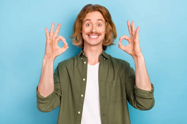 Porträtt av attraktiva glada funky kille visar ok-sign annons cool trevlig lösning isolerad över ljusblå färg bakgrund — Stockfoto