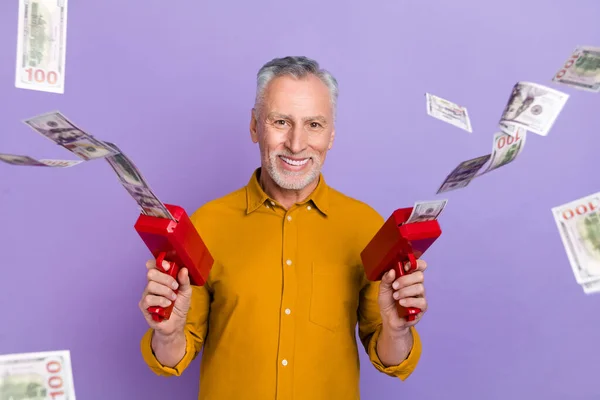 Photo of cheerful mature man rich wasting money shoot gun earnings isolated over violet color background — Stok fotoğraf