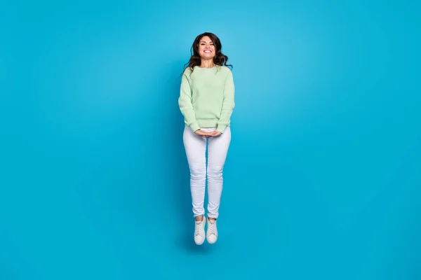 Full size photo of sweet mature brunette lady jump wear shirt pants shoes isolated on blue background — Stockfoto