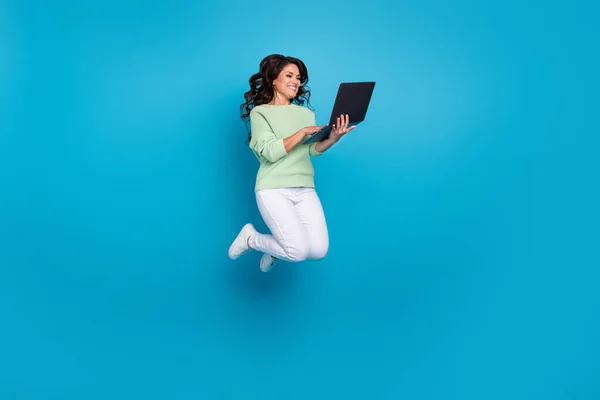 Full storlek foto av söt mogen brunett dam hoppa grepp laptop bära skjorta byxor skor isolerad på blå bakgrund — Stockfoto