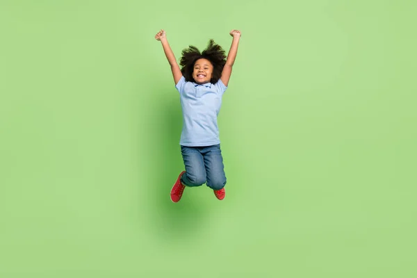 Comprimento total do corpo tamanho vista de bela alegre pré-adolescente menina saltando se divertindo isolado sobre fundo de cor verde — Fotografia de Stock