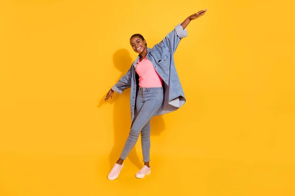 Full size photo of satisfied pretty overjoyed person raise hands enjoy weekend isolated on yellow color background — стоковое фото