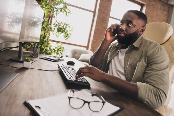 Portrait of attractive focused skilled guy executive manager calling client typing project email at workplace workstation indoors — стоковое фото