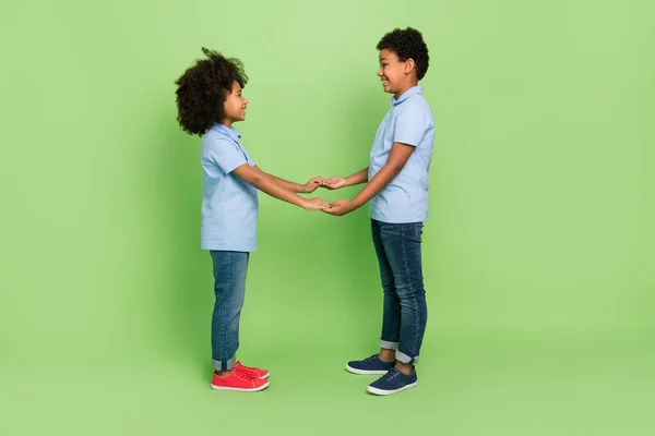 Full length body size view of attractive nice cheerful trendy kind pre-teen kids holding hands isolated on green color background — ストック写真