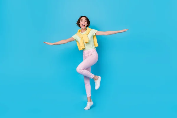 Full size photo of sweet young brunette lady dance wear t-shirt trousers sneakers isolated on blue background — ストック写真