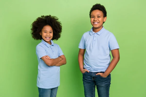 Portrait of attractive cheery trendy pre-teen schoolkids wearing shirts isolated over green color background — Stok fotoğraf