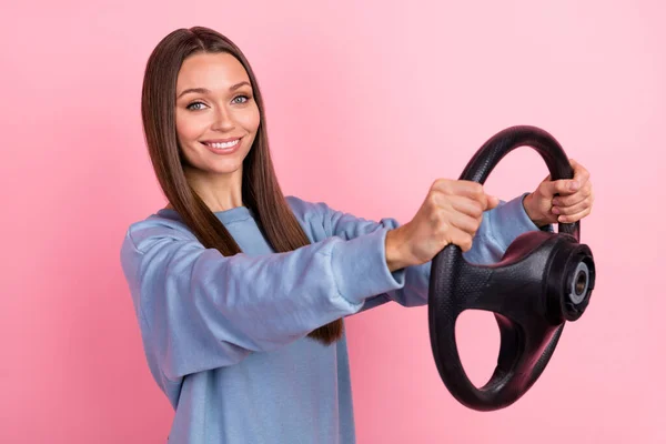 Portrait of attractive cheerful girl holding steering wheel riding free time hobby isolated over pink pastel color background — Zdjęcie stockowe