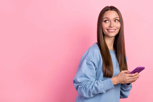 Retrato de menina alegre atraente usando dispositivo olhar para o lado cópia espaço smm aplicativo isolado sobre cor pastel rosa fundo — Fotografia de Stock