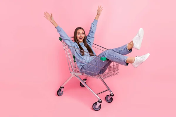 Full length body size view of attractive cheerful girl having fun riding cart isolated over pink pastel color background — Fotografia de Stock