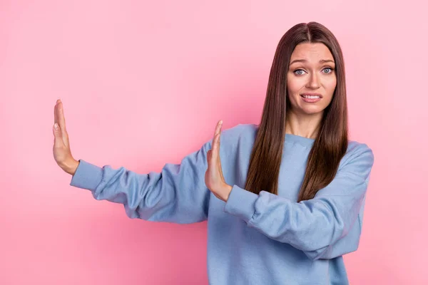 Portrait of attractive worried puzzled girl showing aside stop sign isolated over pink pastel color background — Stockfoto