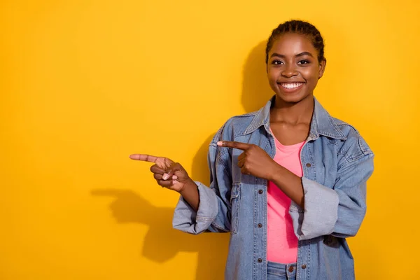 Photo of young pretty girl promoter indicate fingers empty space proposition select sale isolated over yellow color background — Stockfoto