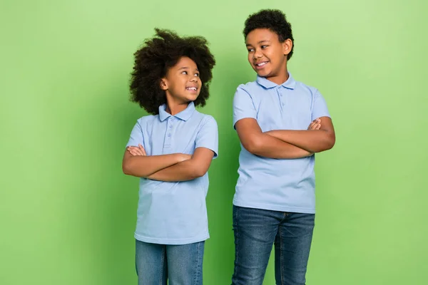 Portrait of beautiful handsome cheerful pre-teen kids folded arms isolated over green color background — Stok fotoğraf