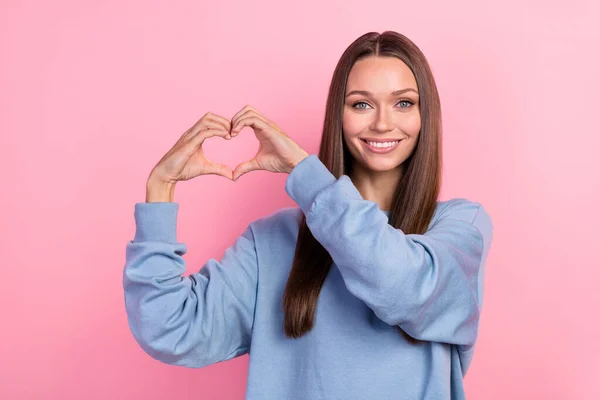 Portrait of attractive affectionate cheerful girl showing heart symbol peace romance isolated over pink pastel color background — Stock fotografie