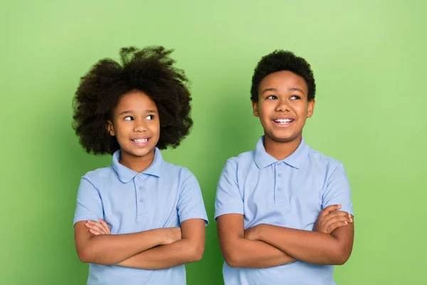 Portrait of two attractive cheerful trendy pre-teen pupils folded arms lesson think isolated over green color background — стоковое фото